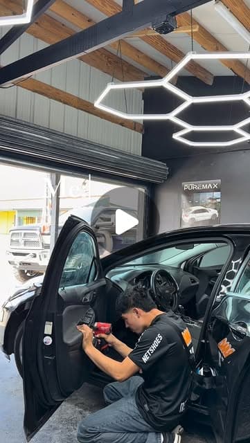 Installer working on a car door inside the tint studio